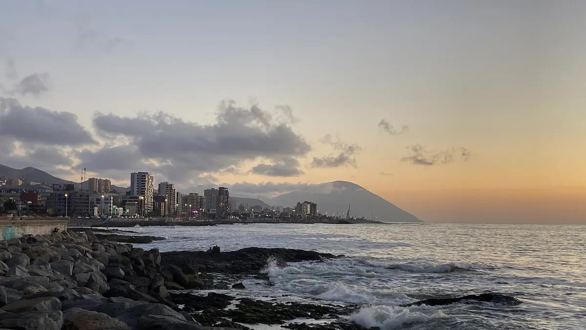 Borde costero de Antofagasta con torres de departamentos y el Pacífico al atardecer