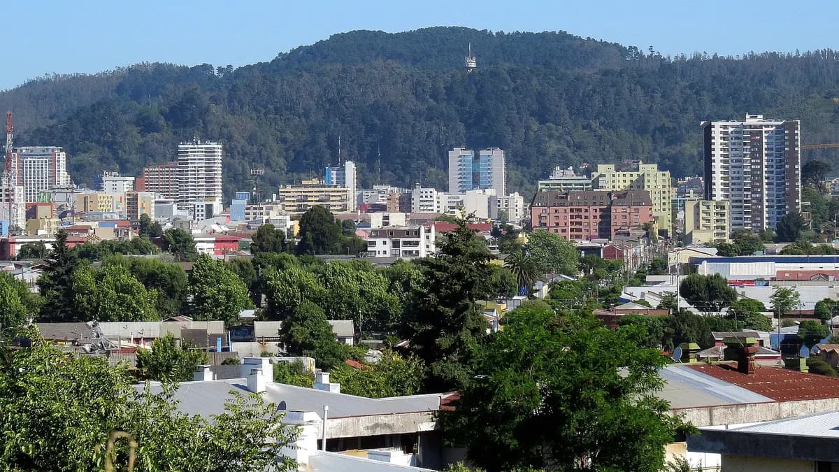 Panorámica de edificios de Concepción con el cerro Caracol verde detrás