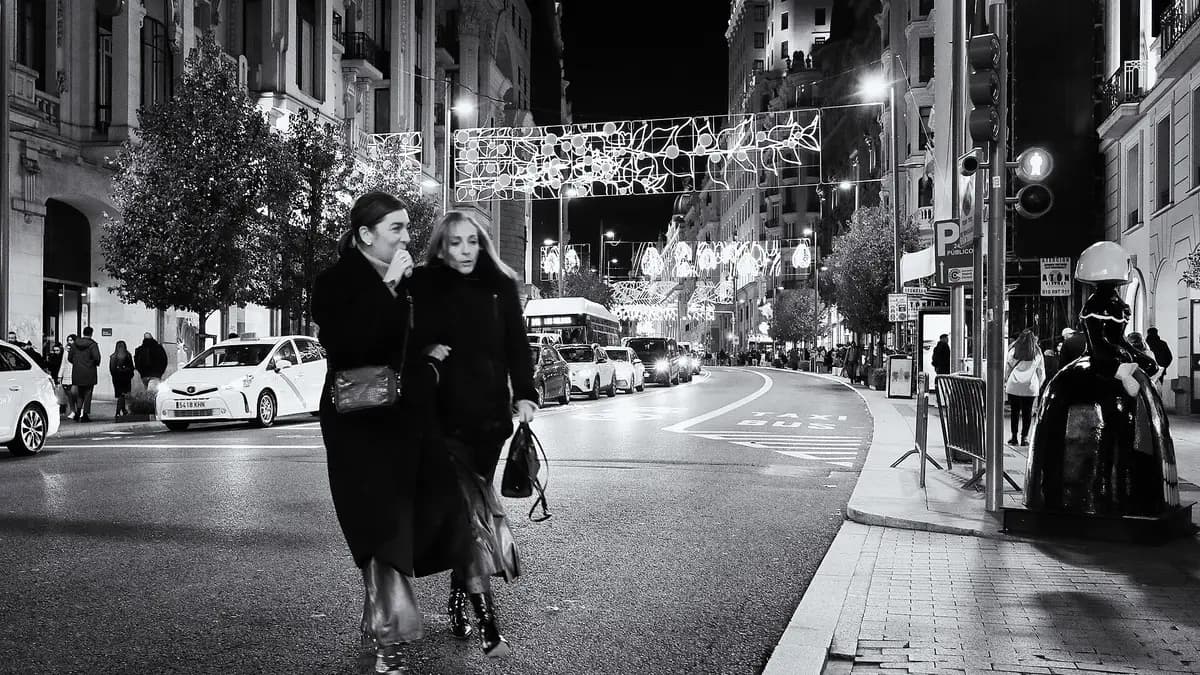 Gran Vía de Madrid de noche con luces navideñas y peatones