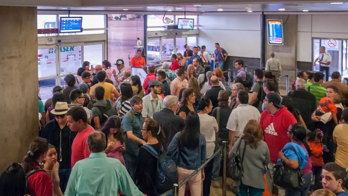 Pasajeros haciendo fila en el hall del aeropuerto internacional de Maiquetía, en Venezuela