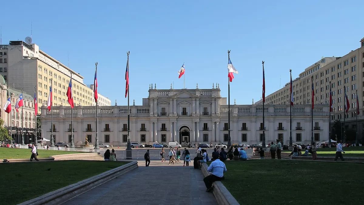 Palacio de gobierno de estilo neoclásico con banderas de Chile frente a la plaza de la Constitución