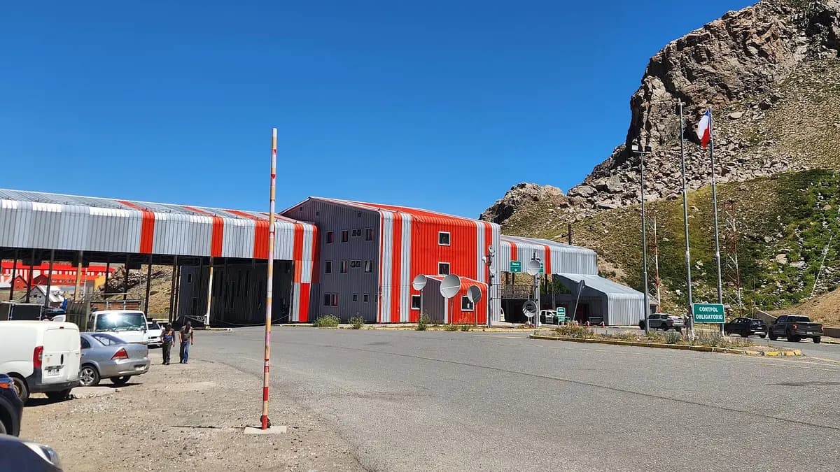 Complejo fronterizo del paso Pehuenche con galpones rojos y la bandera chilena
